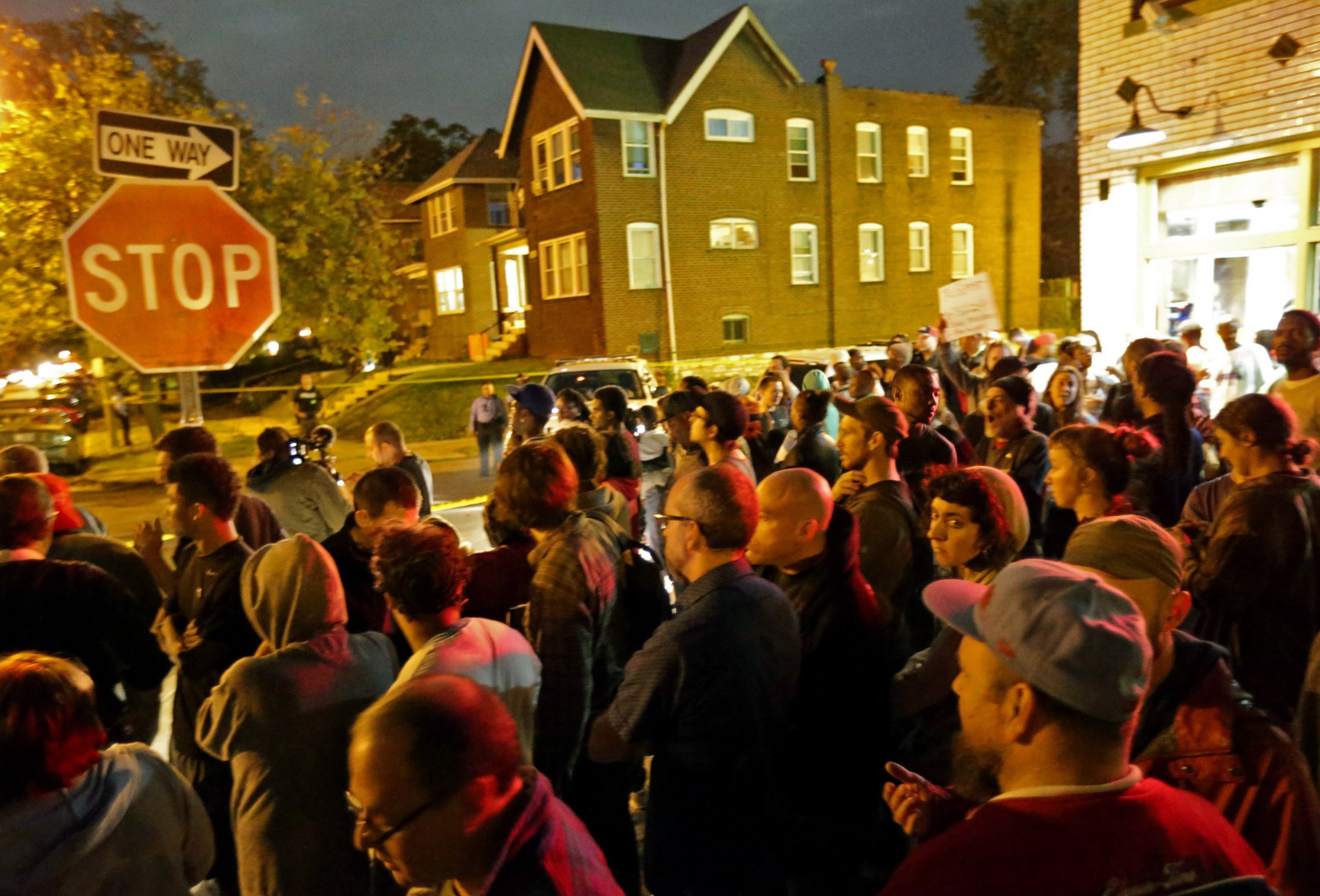 PHOTO: A crowd gathers near the scene in the 4100 block of Shaw Boulevard where a man was fatally shot by an off-duty St. Louis police officer, Oct. 8, 2014.