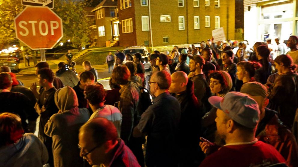 PHOTO: A crowd gathers near the scene in the 4100 block of Shaw Boulevard where a man was fatally shot by an off-duty St. Louis police officer, Oct. 8, 2014.