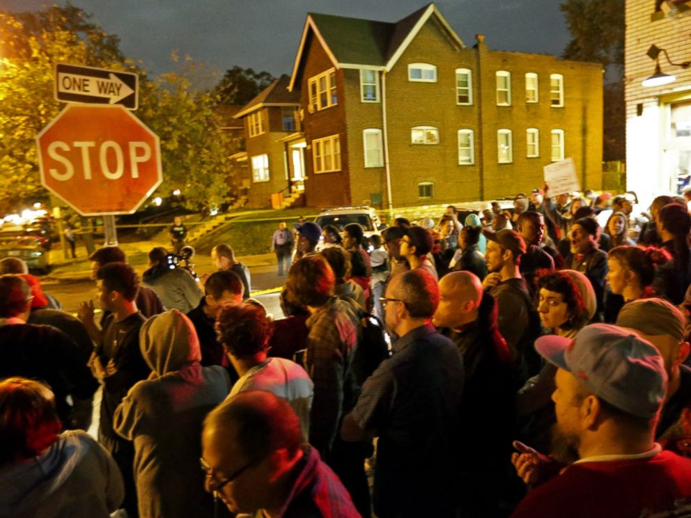 PHOTO: A crowd gathers near the scene in the 4100 block of Shaw Boulevard where a man was fatally shot by an off-duty St. Louis police officer, Oct. 8, 2014.