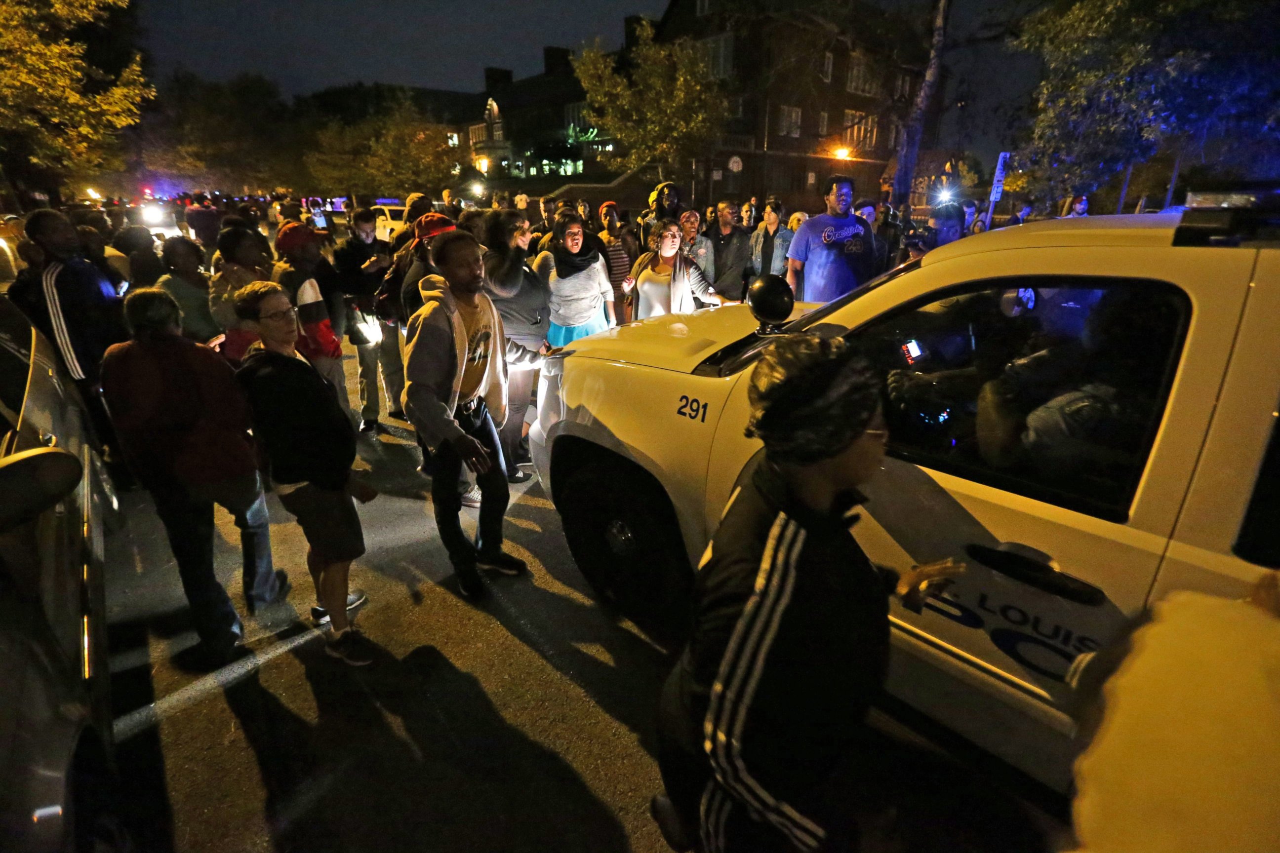 PHOTO: A crowd gathers Wednesday near the scene in south St. Louis where a man was fatally shot by an off-duty St. Louis police officer, Oct. 8, 2014.