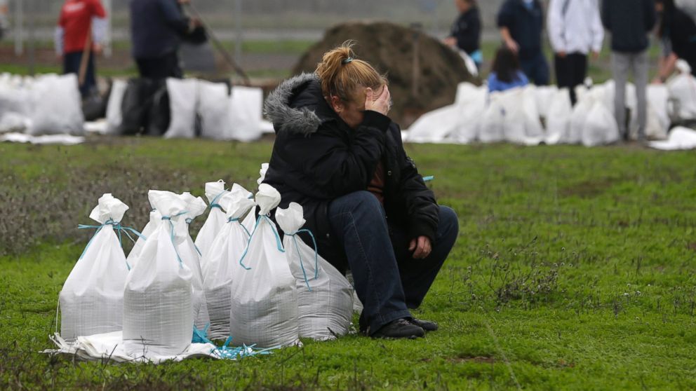 PHOTO: Kathryn Olson rests on a sandbag before carrying it to her vehicle to be used at her home in the Sacramento suburb of North Highlands, Calif., Dec. 10, 2014.