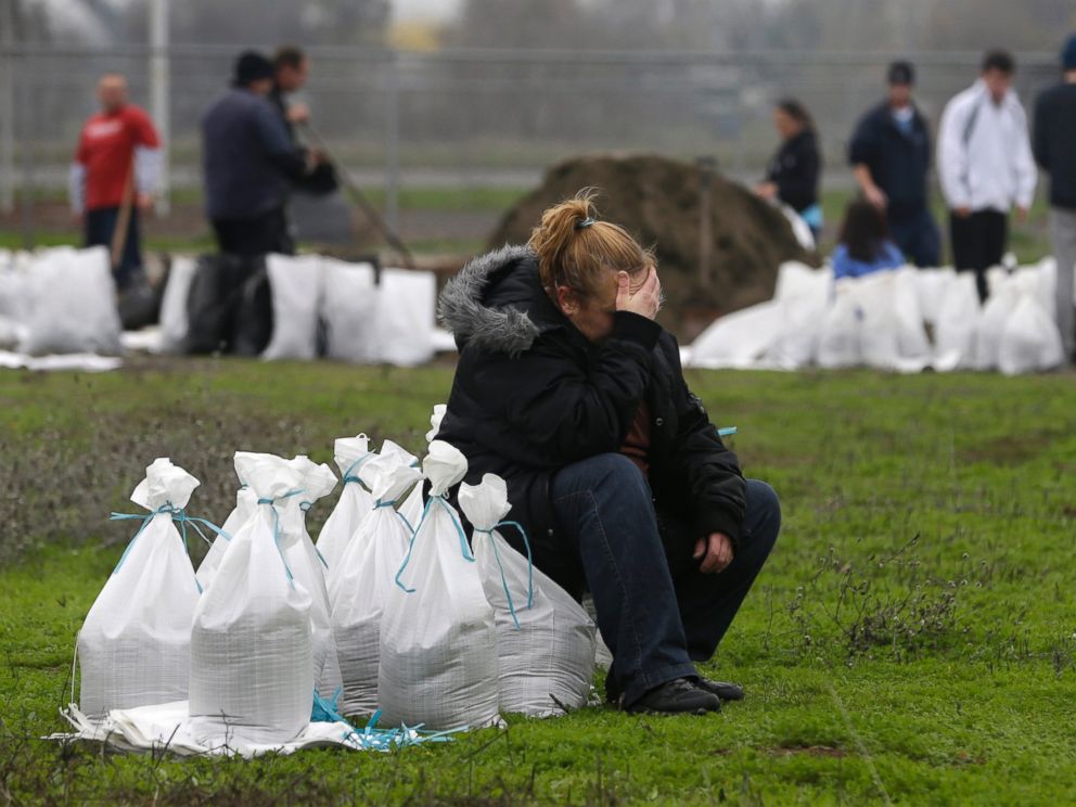 PHOTO: Kathryn Olson rests on a sandbag before carrying it to her vehicle to be used at her home in the Sacramento suburb of North Highlands, Calif., Dec. 10, 2014.