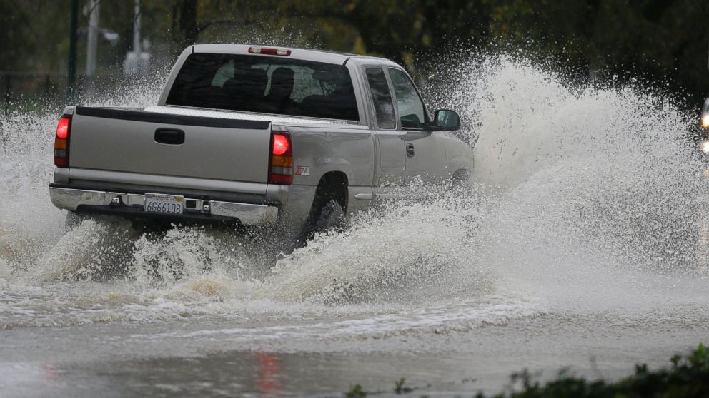 A pickup makes its way down a flooded street, Dec. 11, 2014, in Healdsburg, Calif.
