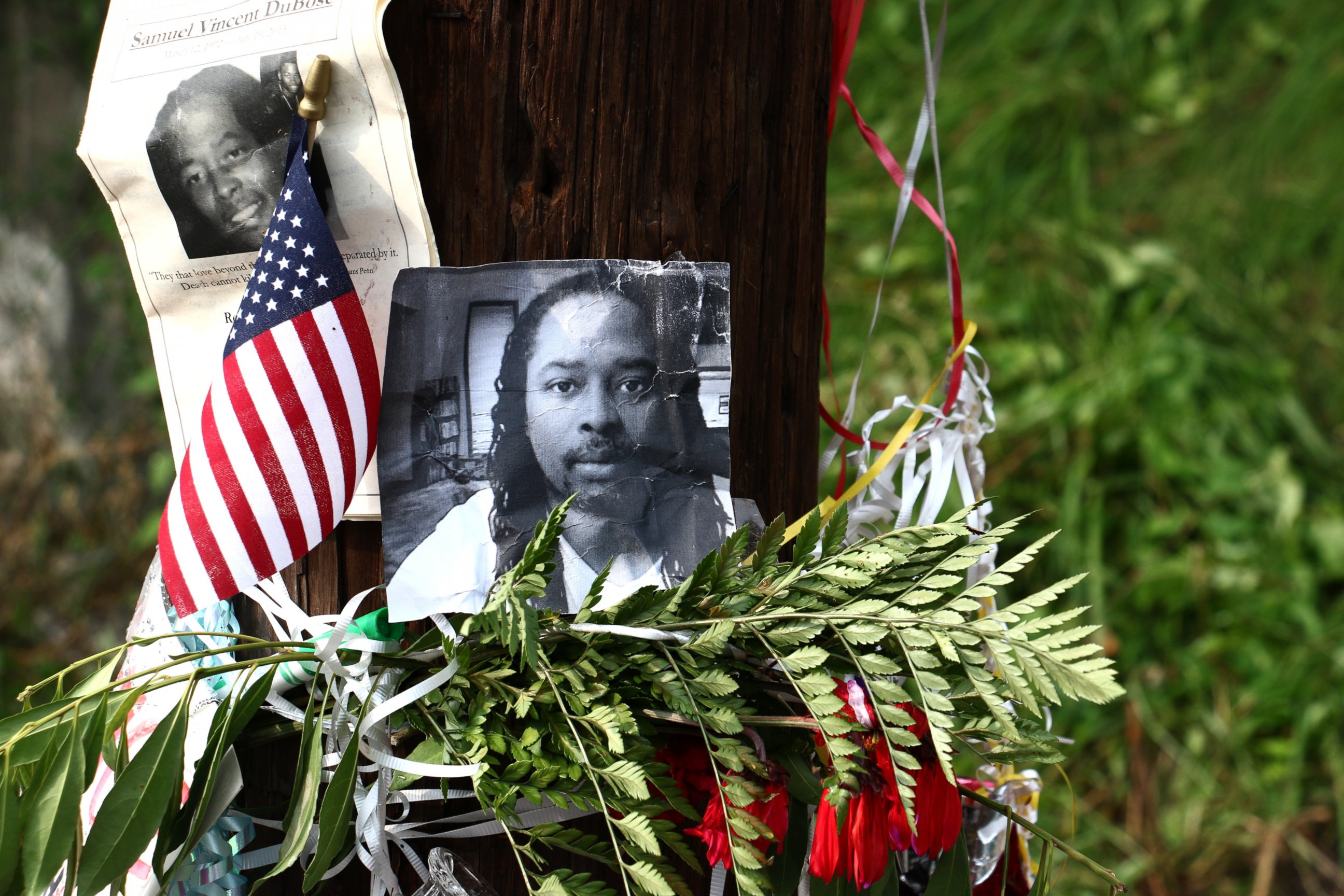 Photos of Samuel DuBose hang on a pole at a memorial, July 29, 2015, in Cincinnati, near where he was shot and killed by a police office. Murder and manslaughter charges were announced against Ray Tensing for the shooting death of DuBose. 