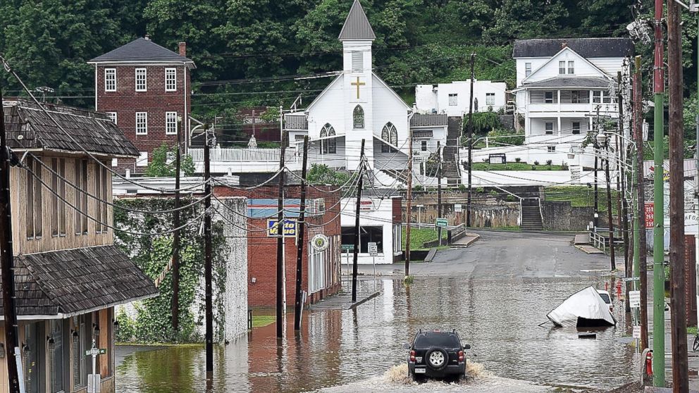 A vehicle makes a wake along the flooded Lower Oakford Ave., June 24, 2016, in Richwood, W.Va. 