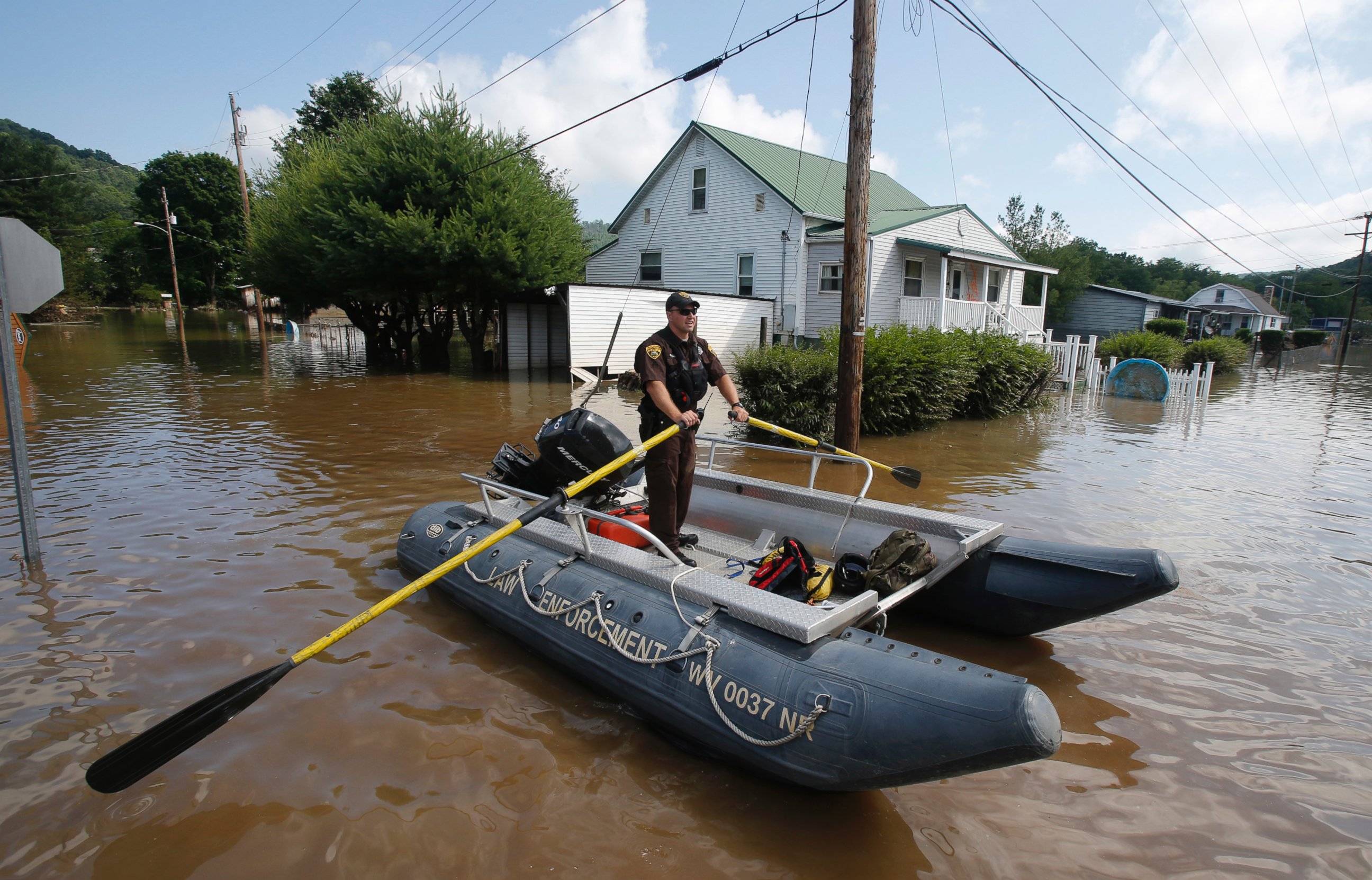PHOTO: Lt. Dennis Feazell, of the West Virginia Department of Natural Resources, rows his boat as he and a co-worker search flooded homes in Rainelle, W.Va., June 25, 2016.  