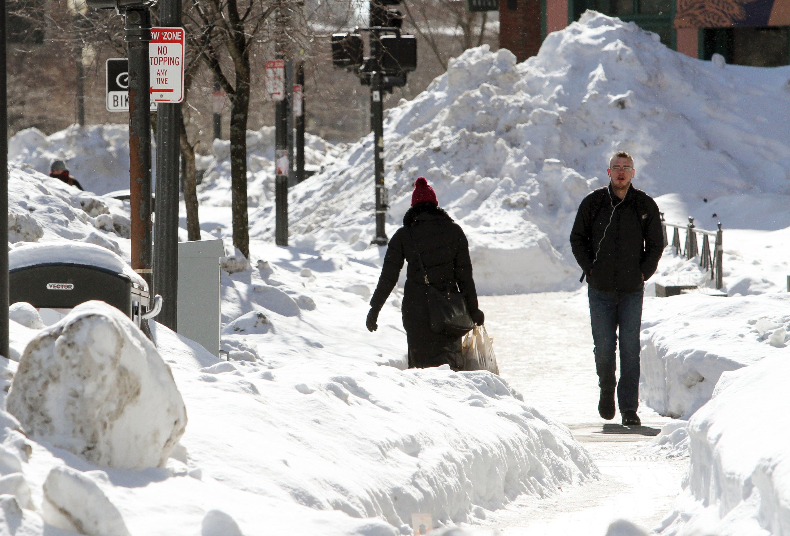 PHOTO: Pedestrians walk among mounds of snow along a street in downtown Boston, Feb. 13, 2015. 