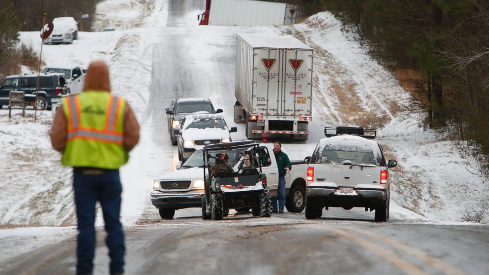 People work to clear stranded vehicles on County Road 25 in Wilsonville, Ala., Jan. 28, 2014.
