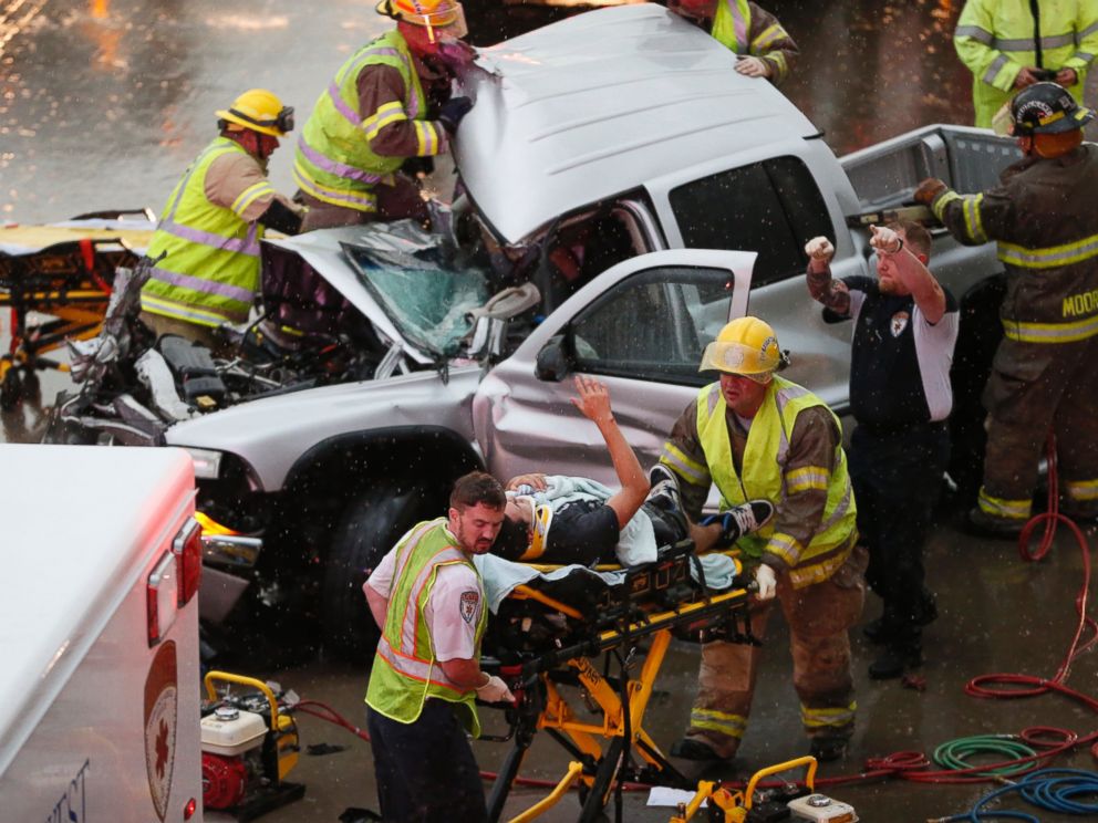 PHOTO: The driver of a truck which crashed during severe weather on Interstate 35 gestures to his rescuers after being cut from the truck in Moore, Okla., May 6, 2015.