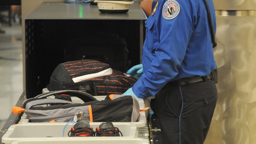 A Transportation Security Administration officer goes through carry on luggage coming out the X-ray scanner at the security checkpoint at Hartsfield-Jackson Atlanta International Airport on Aug. 3, 2011 in Atlanta. 