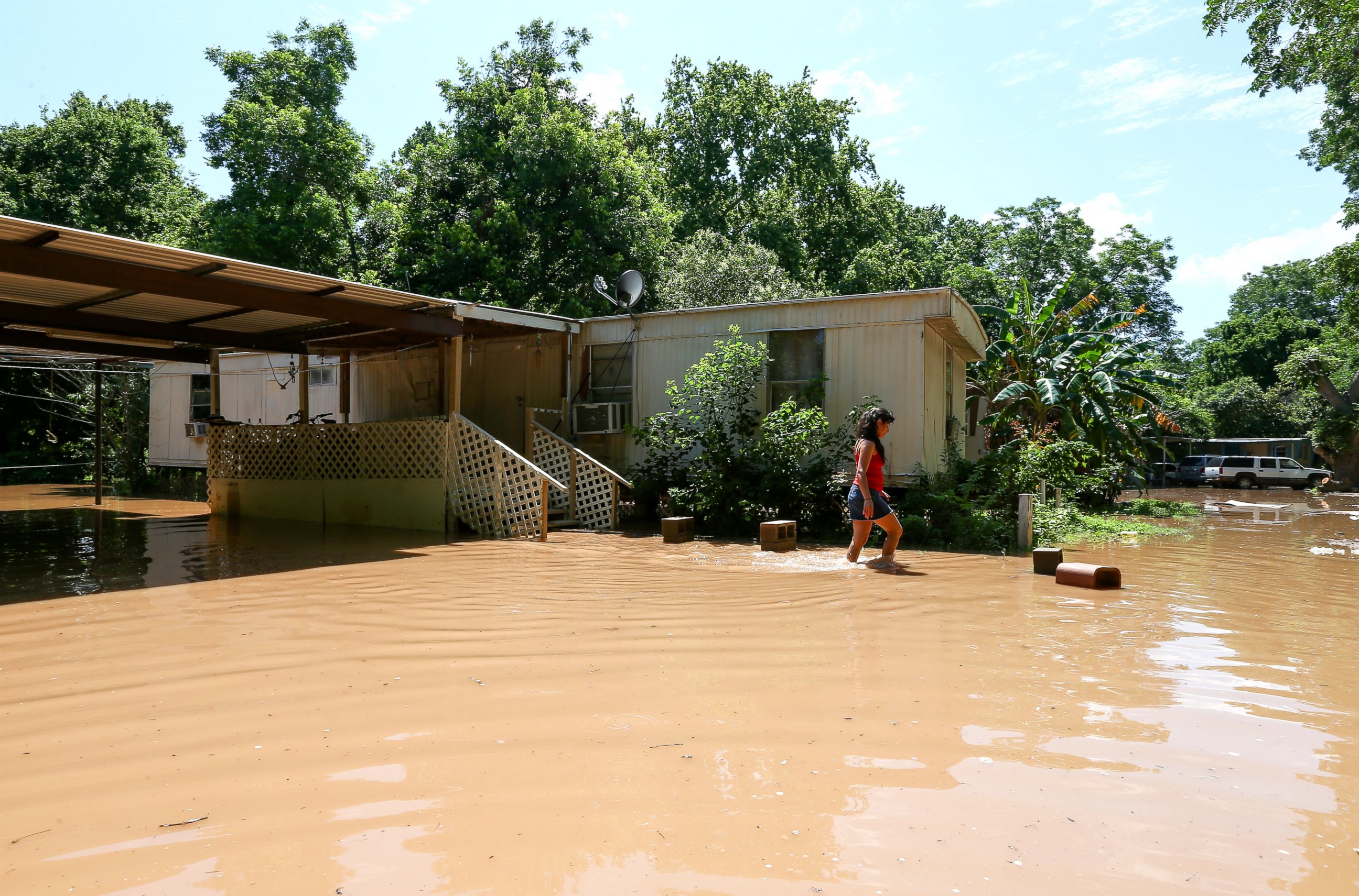 PHOTO:Irene Martinez, who lives near the Brazos River, leaves her flooded home, May 29, 2016, in Richmond, Texas.   