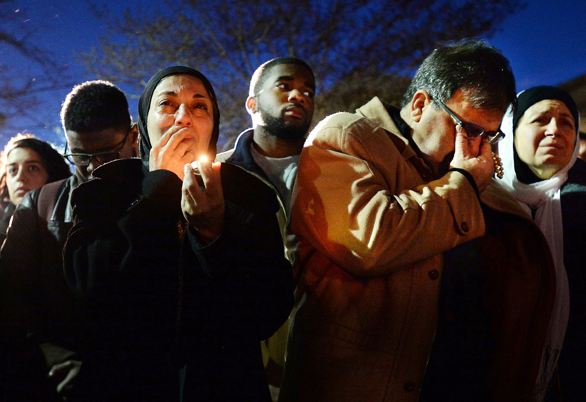 Namee Barakat, right, wipes away tears as he and his wife, Layla, left, watch photos projected on a screen during a vigil for his son, daughter-in-law and her sister, who were killed near UNC-Chapel Hill, Feb. 11, 2015, in Chapel Hill, N.C. 