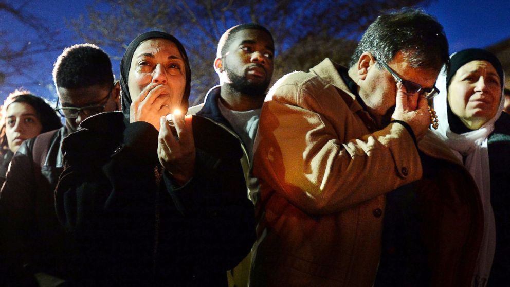 Namee Barakat, right, wipes away tears as he and his wife, Layla, left, watch photos projected on a screen during a vigil for his son, daughter-in-law and her sister, who were killed near UNC-Chapel Hill, Feb. 11, 2015, in Chapel Hill, N.C. 