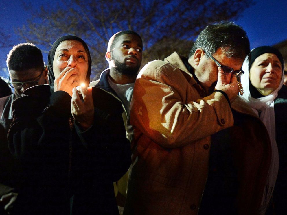 Namee Barakat, right, wipes away tears as he and his wife, Layla, left, watch photos projected on a screen during a vigil for his son, daughter-in-law and her sister, who were killed near UNC-Chapel Hill, Feb. 11, 2015, in Chapel Hill, N.C.