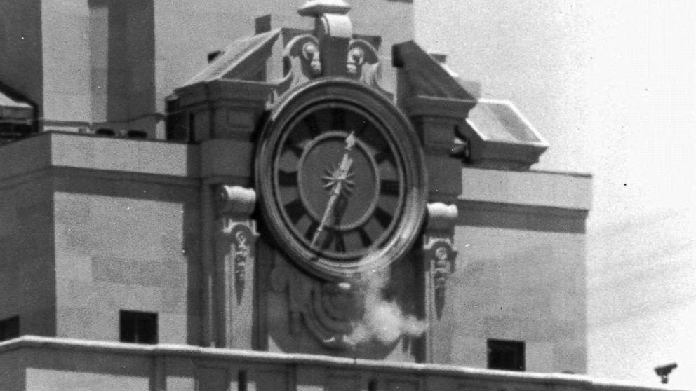 In this Aug. 1, 1966 file photo, smoke rises from the sniper's gun as he fired from the tower of the University of Texas administration building in Austin, Texas, on crowds below. 