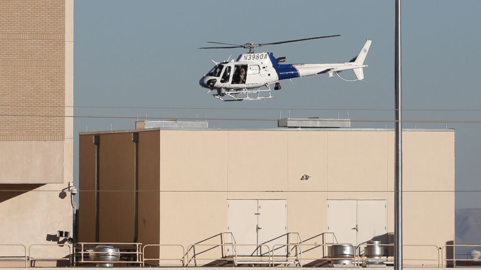 A Department of Homeland Security helicopter flies over the El Paso VA and Beaumont Army Medical Center campus during the search for a gunman in El Paso, Texas, Jan. 6, 2014.