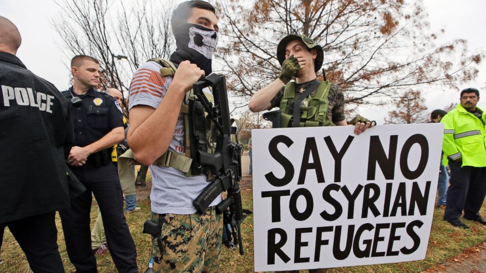 As police stand guard, armed anti-Muslim protestors, who did not want to give their names, stand across the street from a mosque during a demonstration in Richardson, Texas, Dec. 12, 2015. 