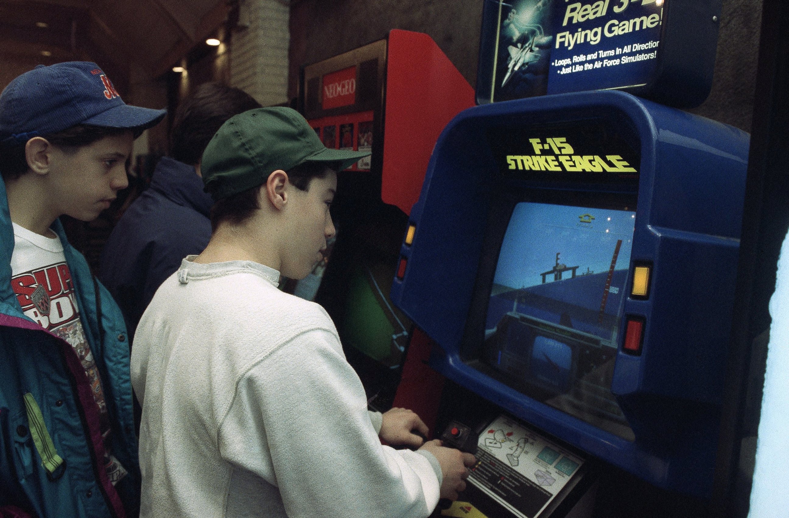 PHOTO: Raymond Freda plays the new F-15 Strike Eagle video game at an arcade in New York in this Jan. 28, 1991, file photo as his friend Brian Valenza looks on.
