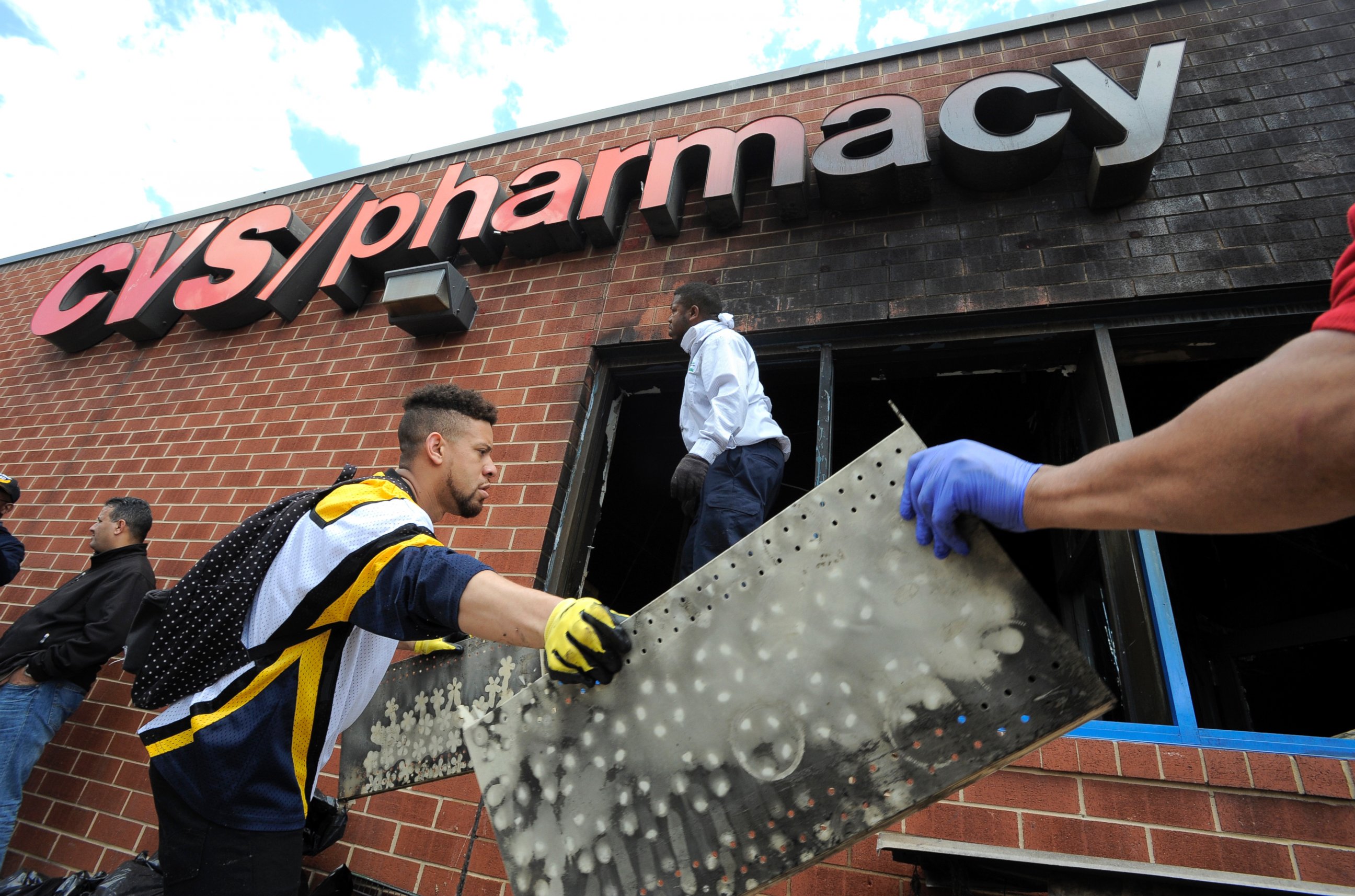 PHOTO: Volunteers work to help clear out the debris from a CVS in Baltimore, April 28, 2015. 