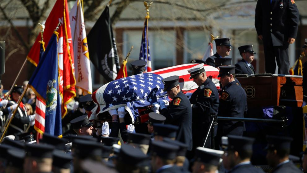 The casket containing the body of Boston firefighter Michael R. Kennedy is carried off his fire truck before his funeral outside Holy Name Church in Boston, April 3, 2014. Kennedy and Boston Fire Lt. Edward J. Walsh were killed March 26, 2014 when they were trapped in the basement of a burning brownstone during a nine-alarm blaze.