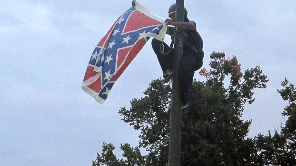 Bree Newsome of Charlotte, N.C., removes the Confederate battle flag at a Confederate monument at the Statehouse in Columbia, S.C., June, 27, 2015. 