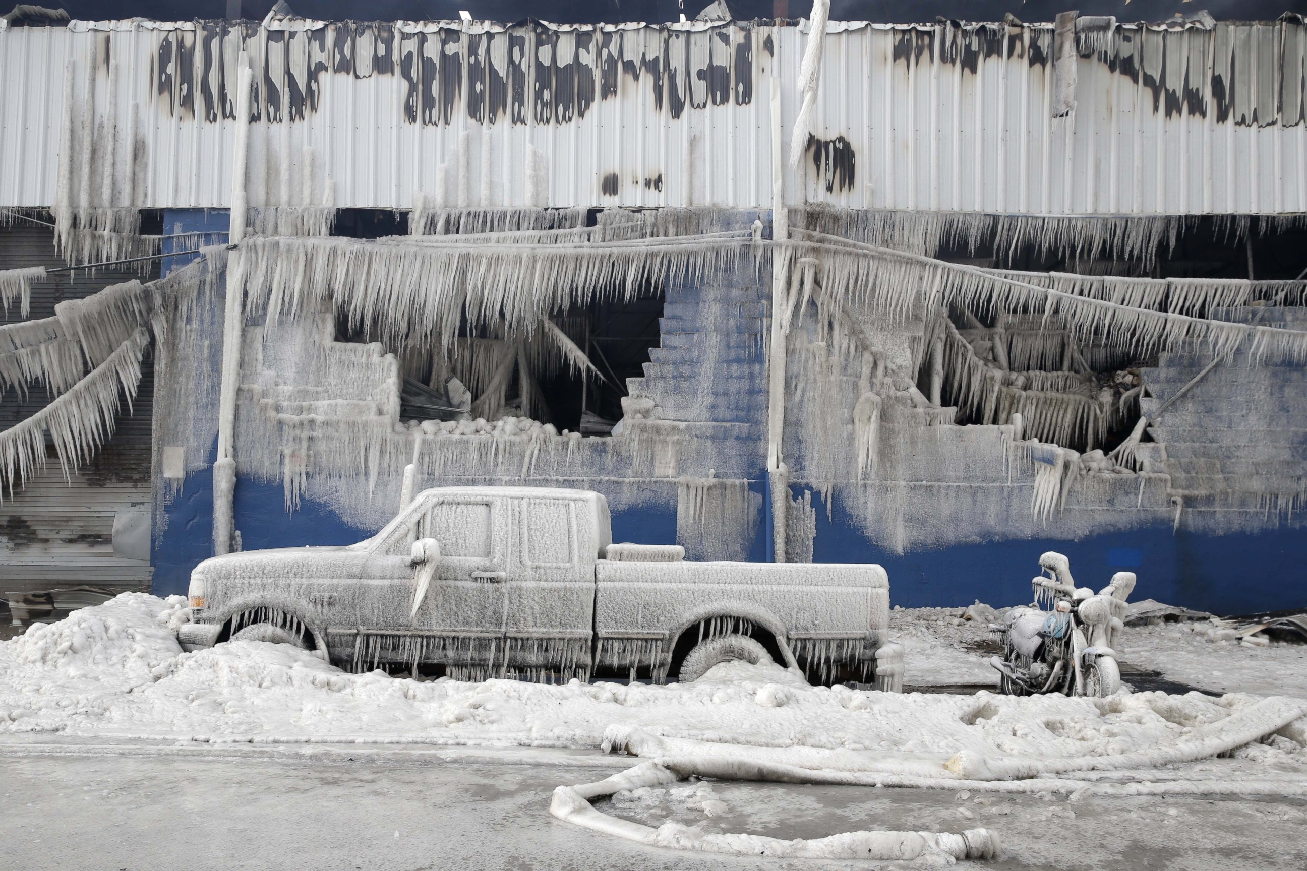 PHOTO: Vehicles and a building are covered with ice as firefighters work to keep a warehouse fire down in the Brooklyn borough of New York, Sunday, Feb. 1, 2015. 