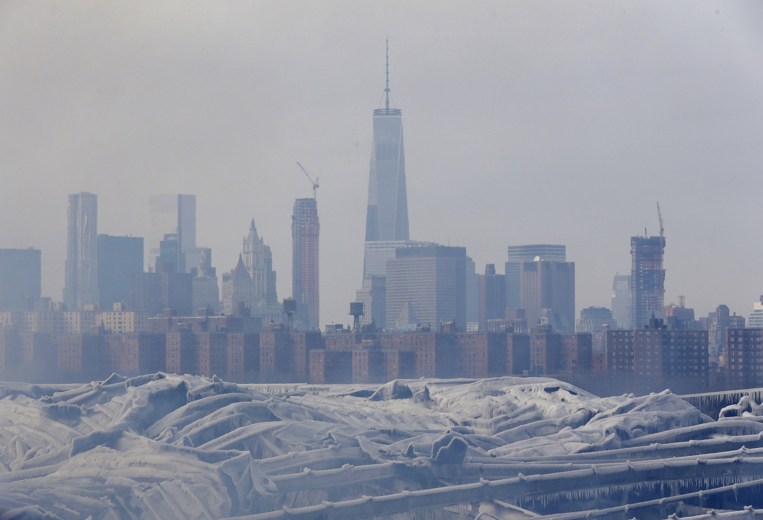 PHOTO: The Manhattan skyline can barely been seen over a smoldering fire in a warehouse in the Brooklyn borough of New York, Sunday, Feb. 1, 2015. 