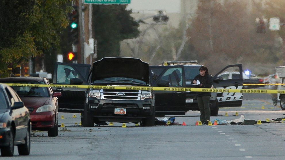 An investigator looks at a Black SUV that was involved in a police shootout with suspects, Dec. 3, 2015, in San Bernardino, Calif.