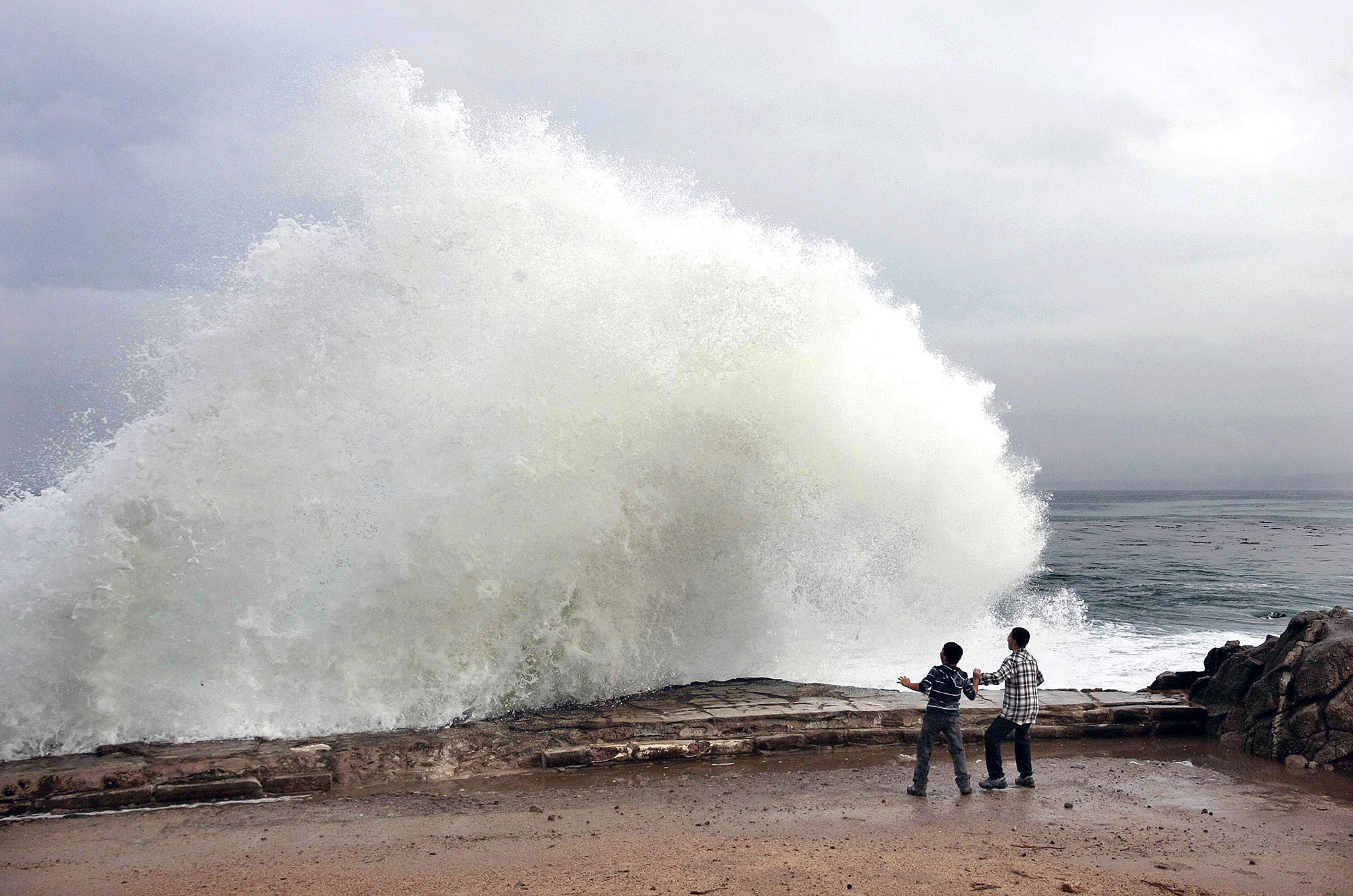 PHOTO: Aidan Stephenson,12, and Conor Stephenson,10, visiting from Phoenix, watch the waves break on Ocean View Boulevard, Dec. 10, 2014, in Pacific Grove, Calif.