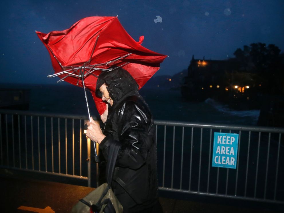 PHOTO: Commuter ML Mann struggles in the wind and rain to make her way to catch a ferry, Dec. 11, 2014, to San Francisco from Sausalito, Calif.