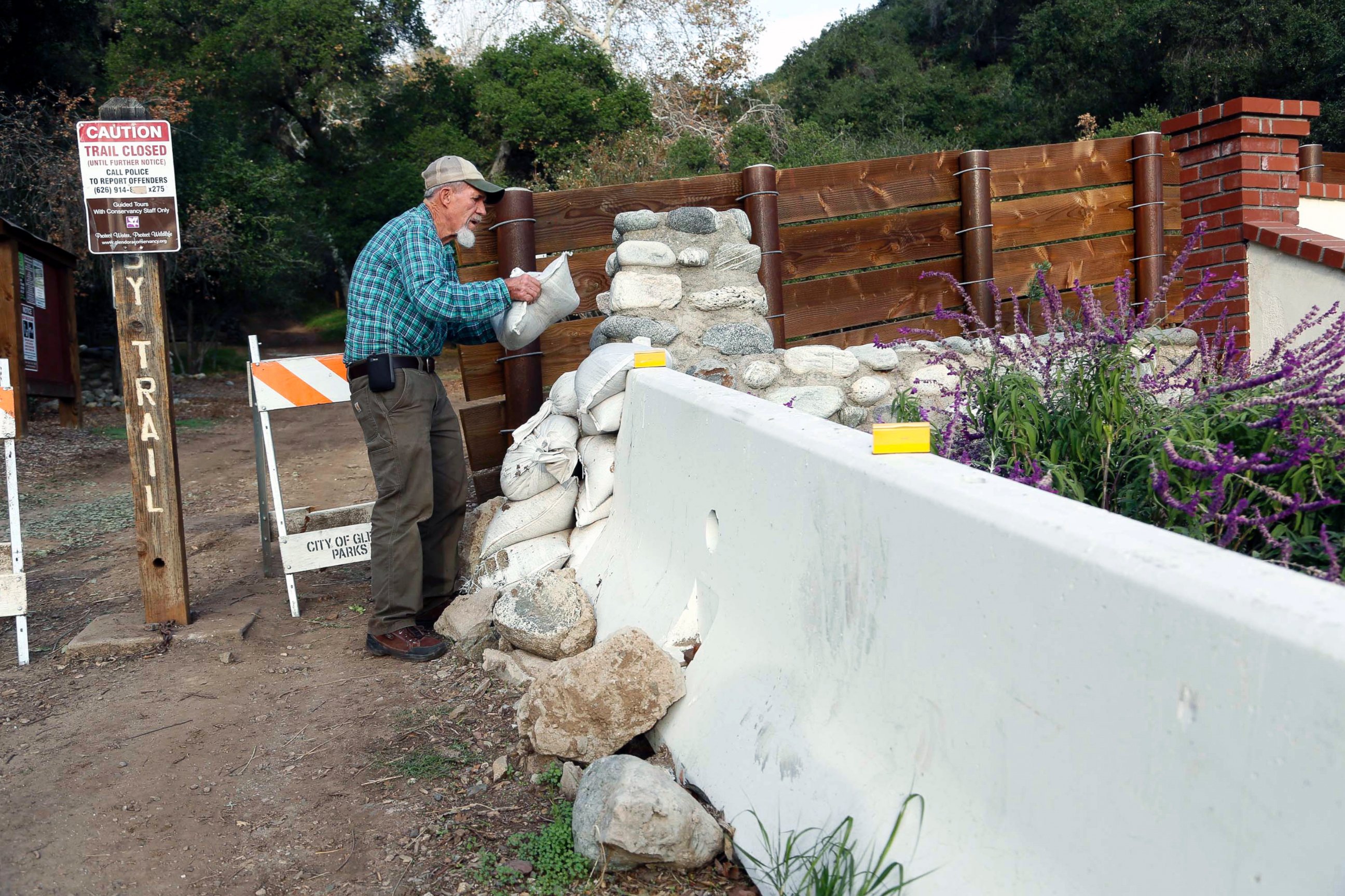PHOTO: Jerry Croissant, 77, places sandbags to protect his home from mudslides outside his home in Gelndra, Calif., below mountains burned over in wildfires, Dec. 10, 2014.