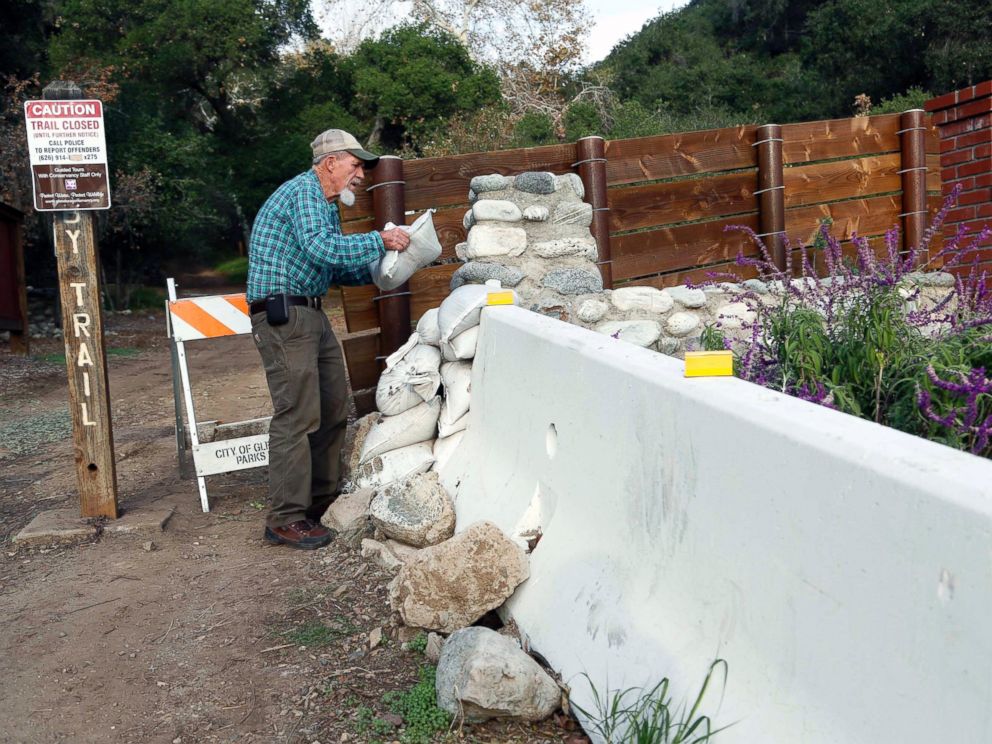 PHOTO: Jerry Croissant, 77, places sandbags to protect his home from mudslides outside his home in Gelndra, Calif., below mountains burned over in wildfires, Dec. 10, 2014.