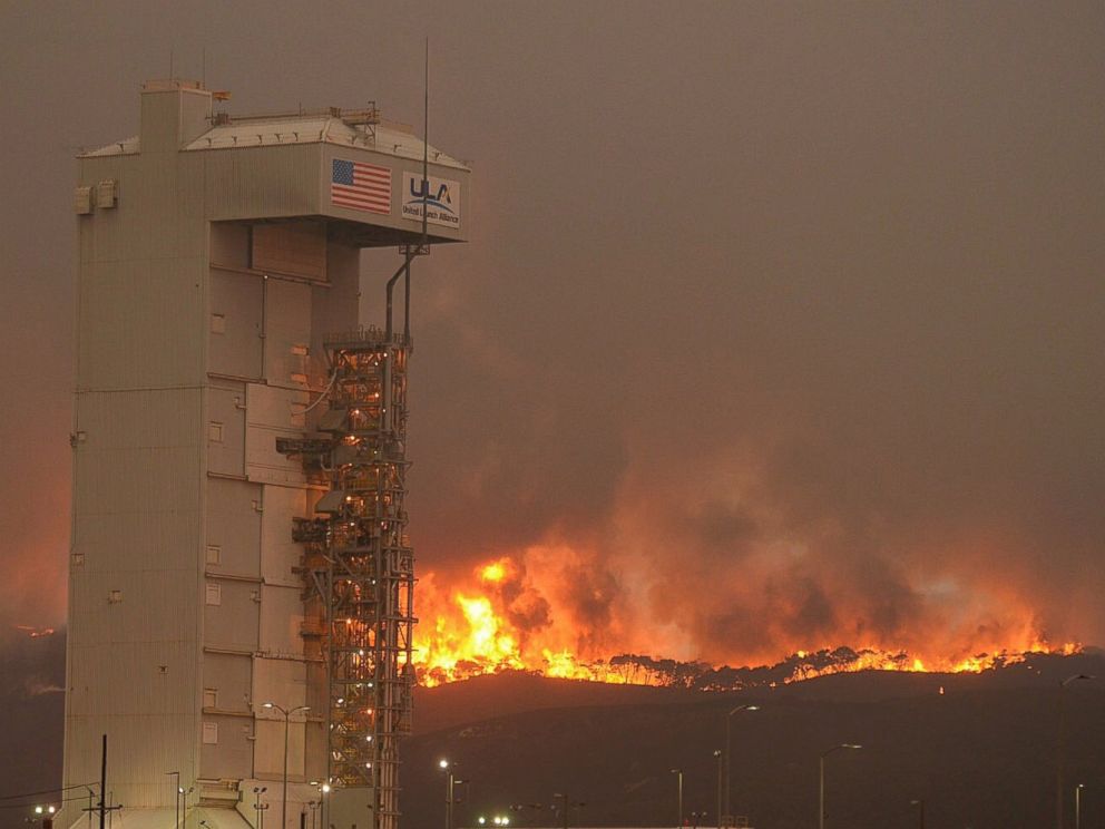 PHOTO: In this Monday, Sept. 19, 2016 photo provided by the Santa Barbara County Fire Department, a fire burns several miles behind Space Launch Complex-3, housing the Atlas V rocket & WorldView 4 satellite, at Vandenberg Air Force Base, California.