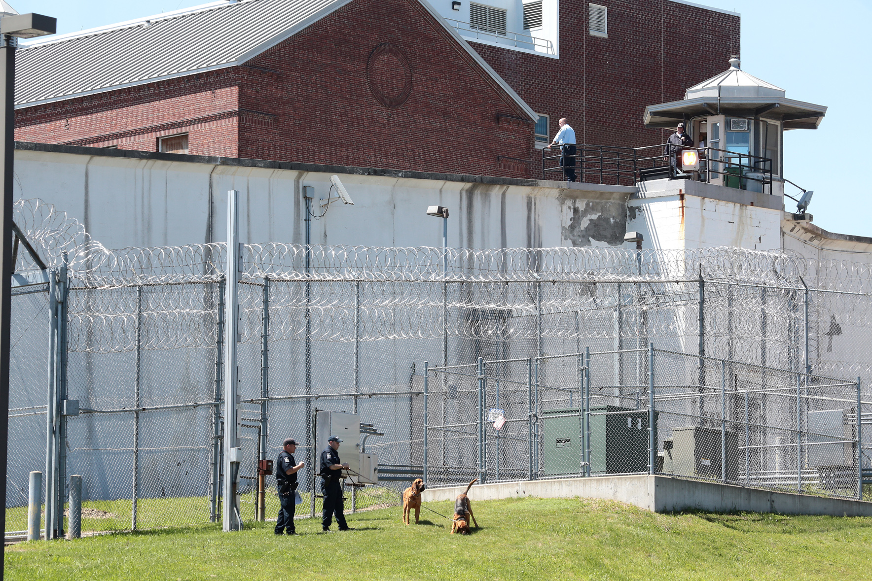 PHOTO: Law enforcement officers with bloodhounds stand guard at one of the entrances to the Clinton Correctional Facility in Dannemora, N.Y. on Saturday, June 6, 2015.