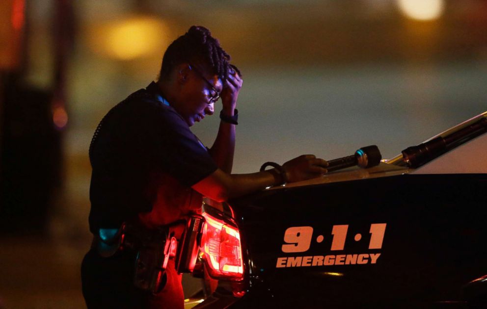 PHOTO: A Dallas police officer, takes a moment as she guards an intersection after a shooting in downtown Dallas, July 8, 2016.