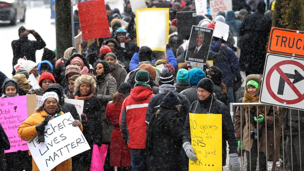 Protesters wait to cross the street on Jan. 20, 2016, in Detroit. Most of Detroit's public schools closed for the day due to teacher absences, as disgruntled educators stepped up efforts to protest the governor's plans for the district.