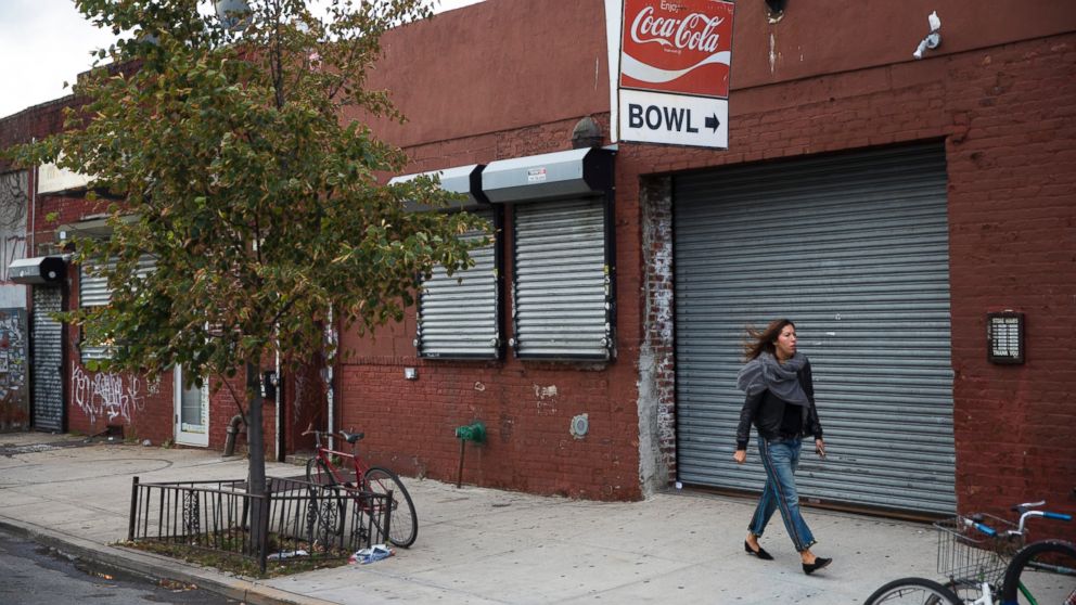 PHOTO: A pedestrian walks past The Gutter bowling alley in the Williamsburg neighborhood of New York on Friday, Oct. 24, 2014.