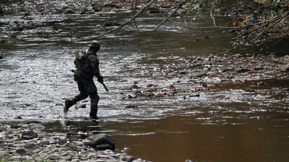 PHOTO: A U.S. marshal patrols along Mill Creek near Clarks Road in Barrett Township, Pennsylvania, Sept 29, 2014, during the search for Eric Frein.