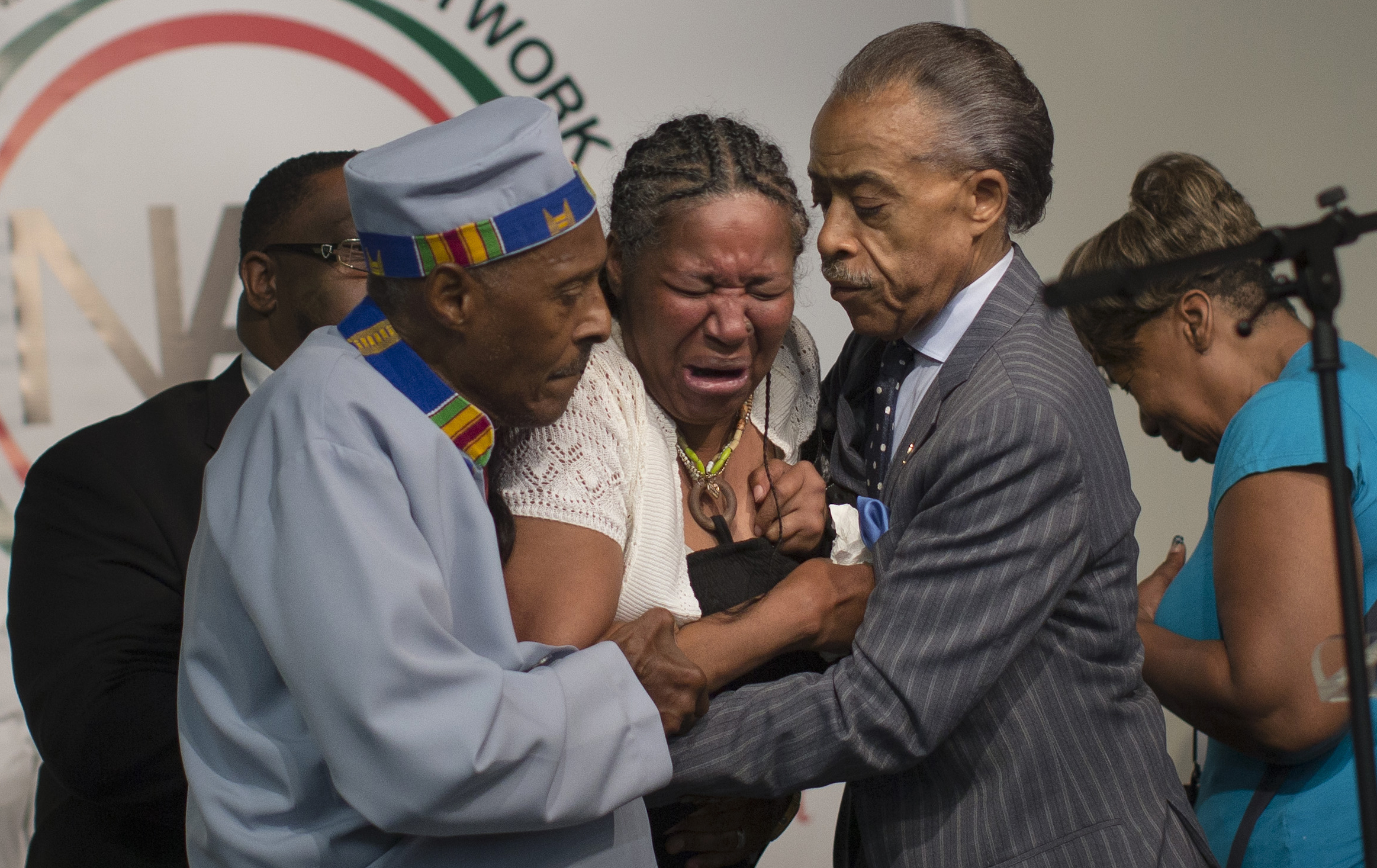 PHOTO: Esaw Garner, wife of Eric Garner, breaks down in the arms of Rev. Herbert Daughtry, center, and Rev. Al Sharpton, right, during a rally at the National Action Network headquarters for Eric Garner, Saturday, July 19, 2014, in New York.