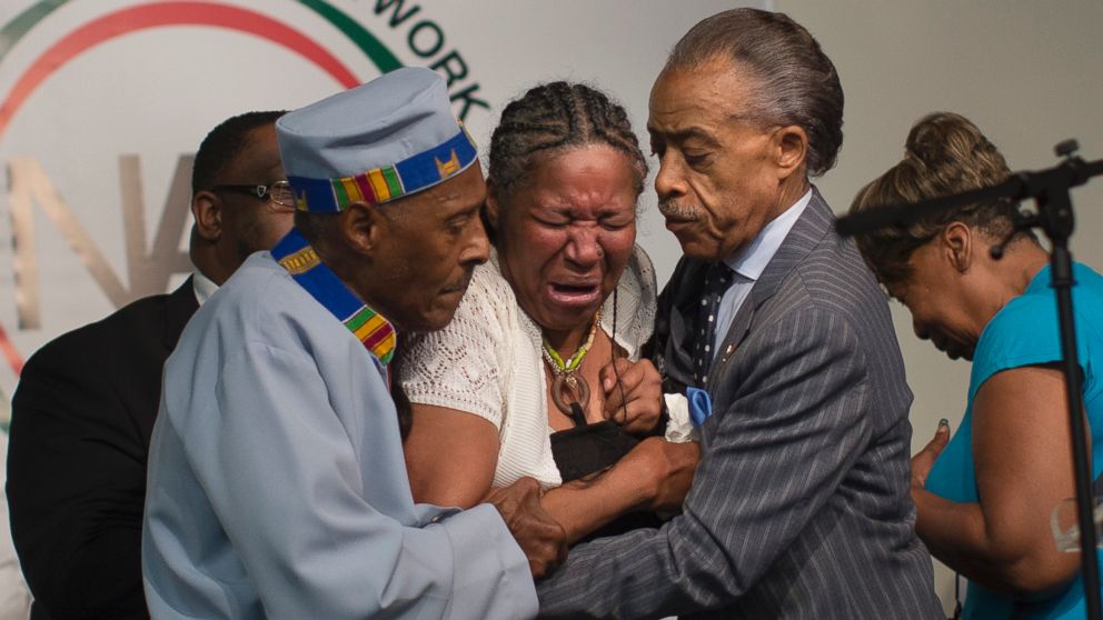 Esaw Garner, wife of Eric Garner, breaks down in the arms of Rev. Herbert Daughtry, center, and Rev. Al Sharpton, right, during a rally at the National Action Network headquarters for Eric Garner, Saturday, July 19, 2014, in New York.