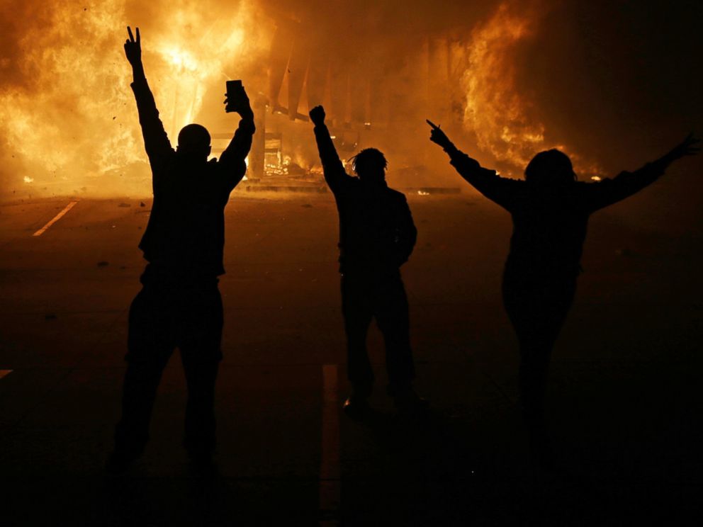 PHOTO: People watch as stores burn, Nov. 25, 2014, in Ferguson, Mo.