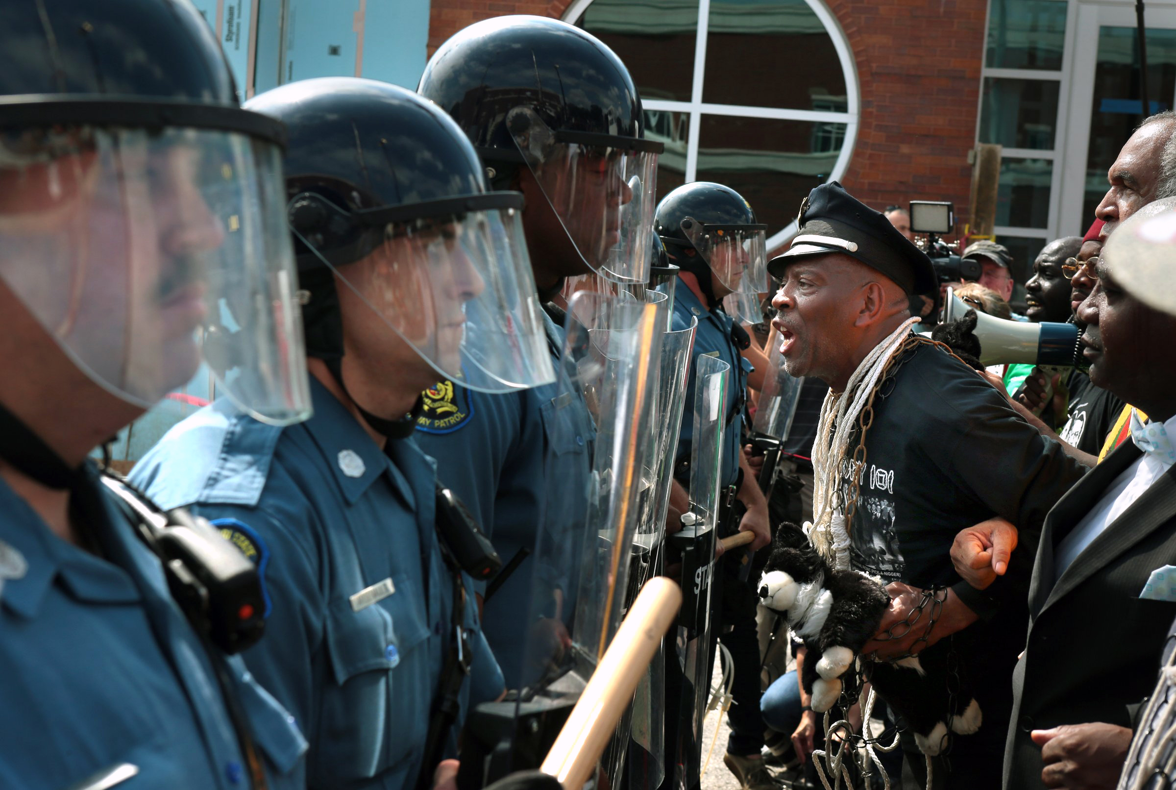 PHOTO: Protester Anthony Shahid leads marchers as they confront Missouri State Highway Patrol trooper in front of the Ferguson police station, Aug. 11, 2014, in Ferguson, Mo.