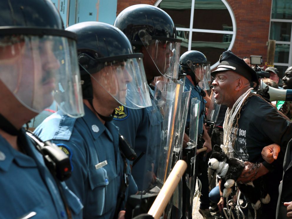 PHOTO: Protester Anthony Shahid leads marchers as they confront Missouri State Highway Patrol trooper in front of the Ferguson police station, Aug. 11, 2014, in Ferguson, Mo.