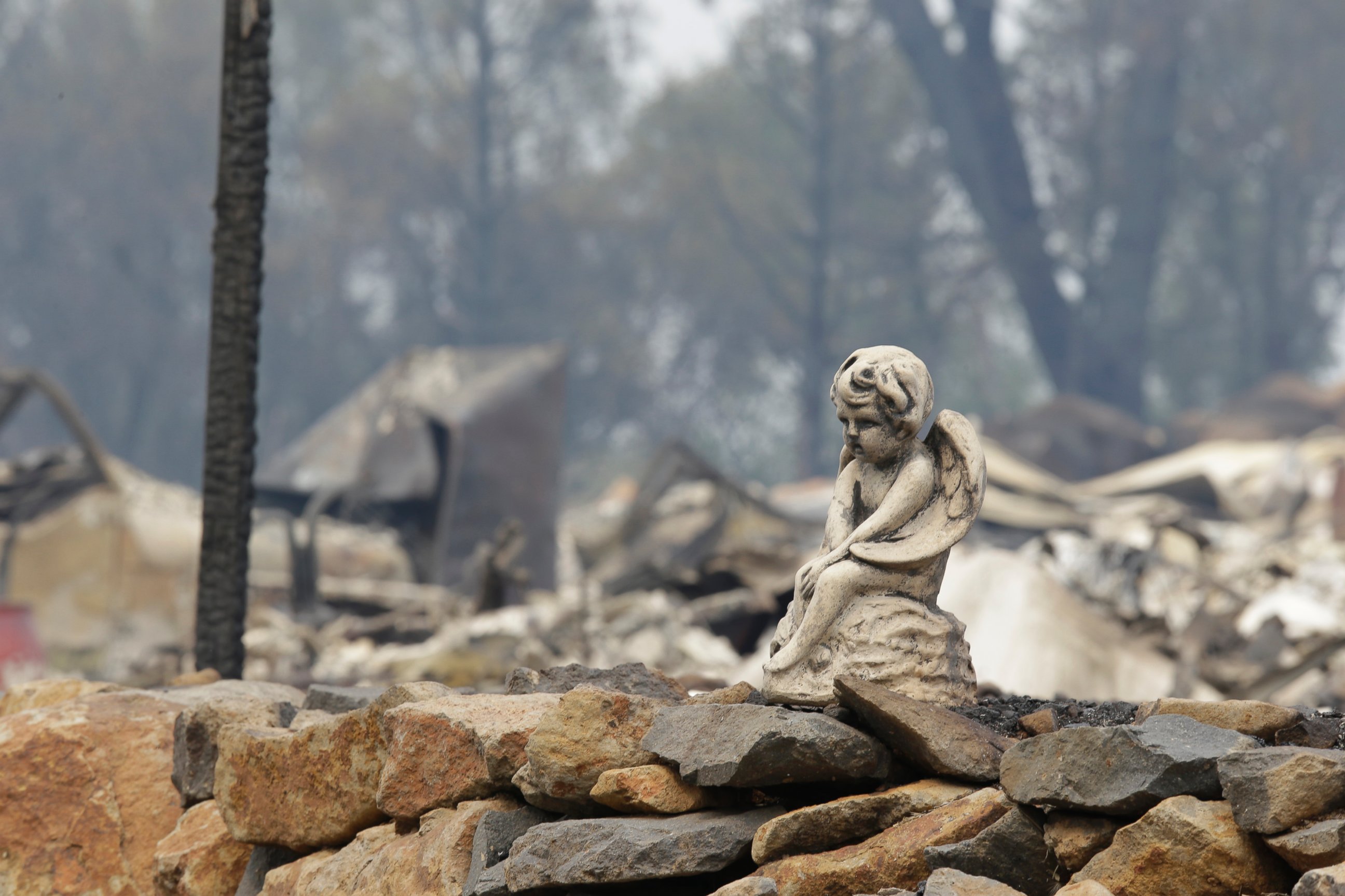 PHOTO: The figure sits on a rock wall outside a hillside home destroyed by fire Sunday, Sept. 13, 2015, in Hidden Valley, Calif.