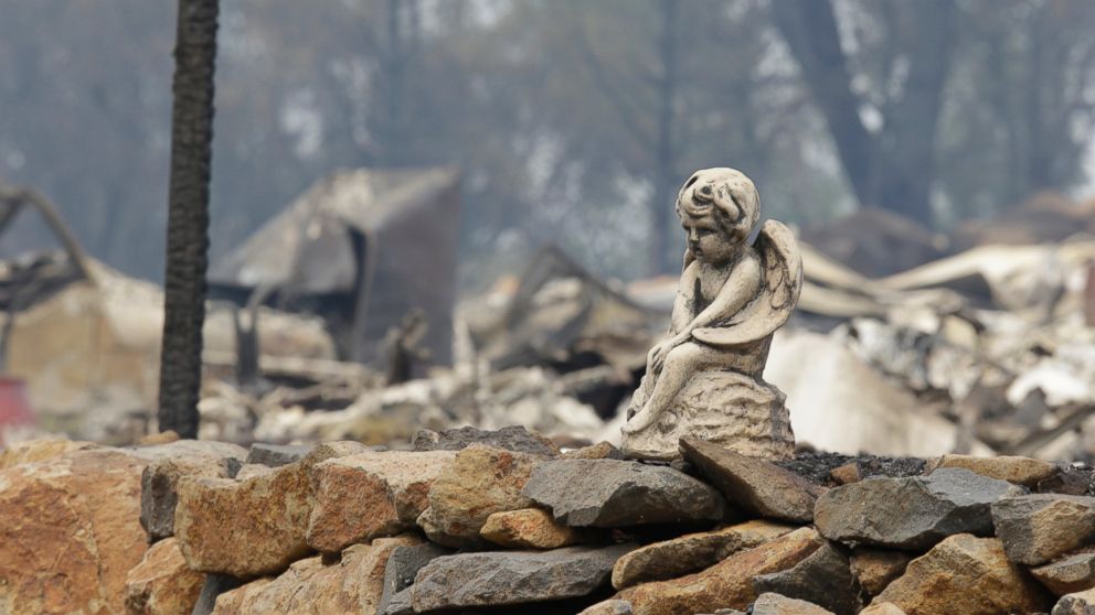 PHOTO: The figure sits on a rock wall outside a hillside home destroyed by fire Sunday, Sept. 13, 2015, in Hidden Valley, Calif.