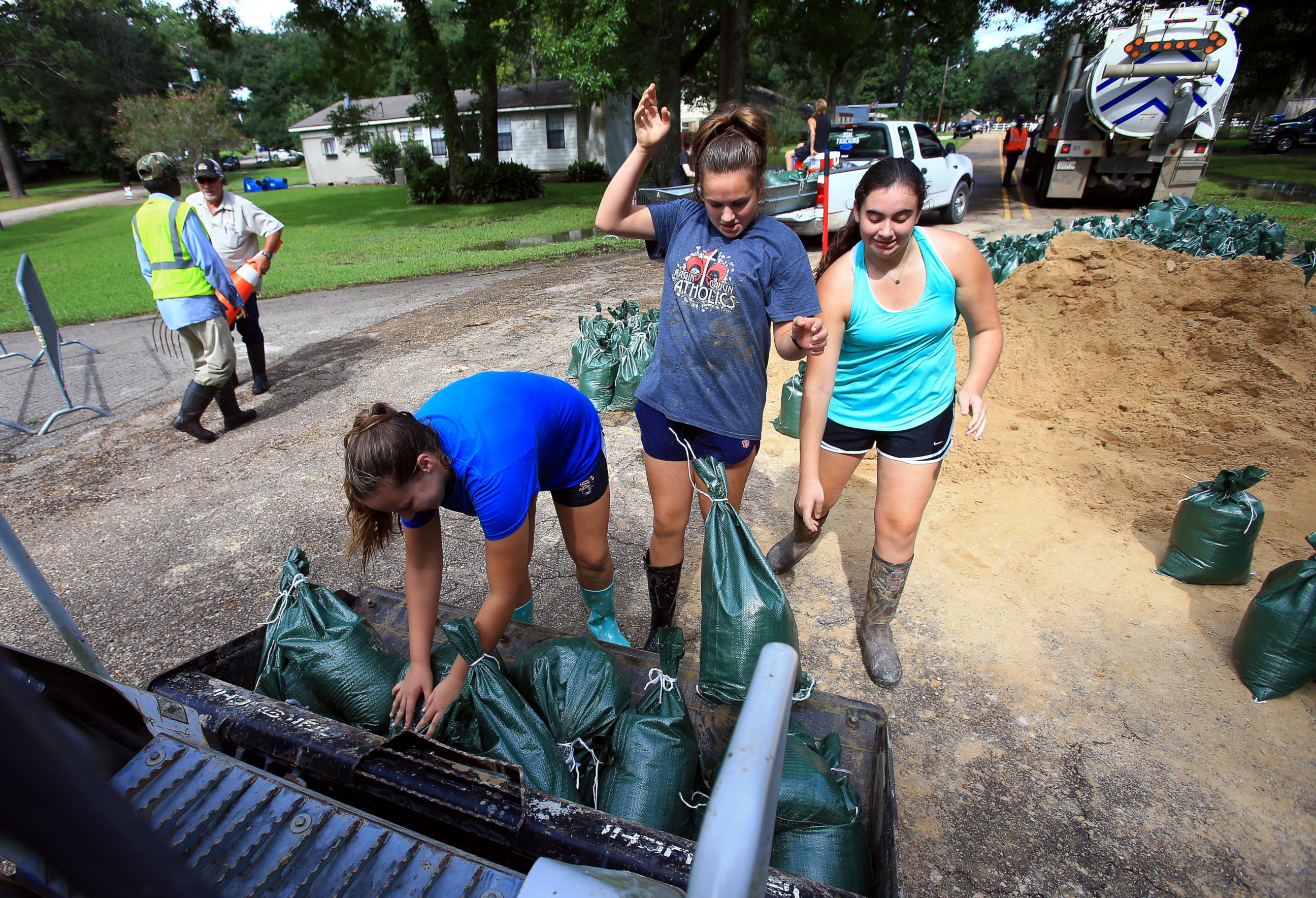PHOTO: Volunteers from Teurlings Catholic High School add sandbags to a tractor loader as volunteers place sandbags near a levy located in the River Oaks neighborhood in Lafayette, Louisiana, Aug. 15, 2016. 