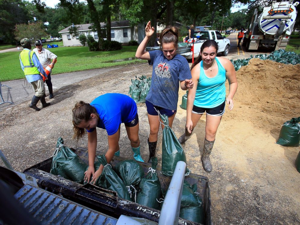 PHOTO: Volunteers from Teurlings Catholic High School add sandbags to a tractor loader as volunteers place sandbags near a levy located in the River Oaks neighborhood in Lafayette, Louisiana, Aug. 15, 2016.