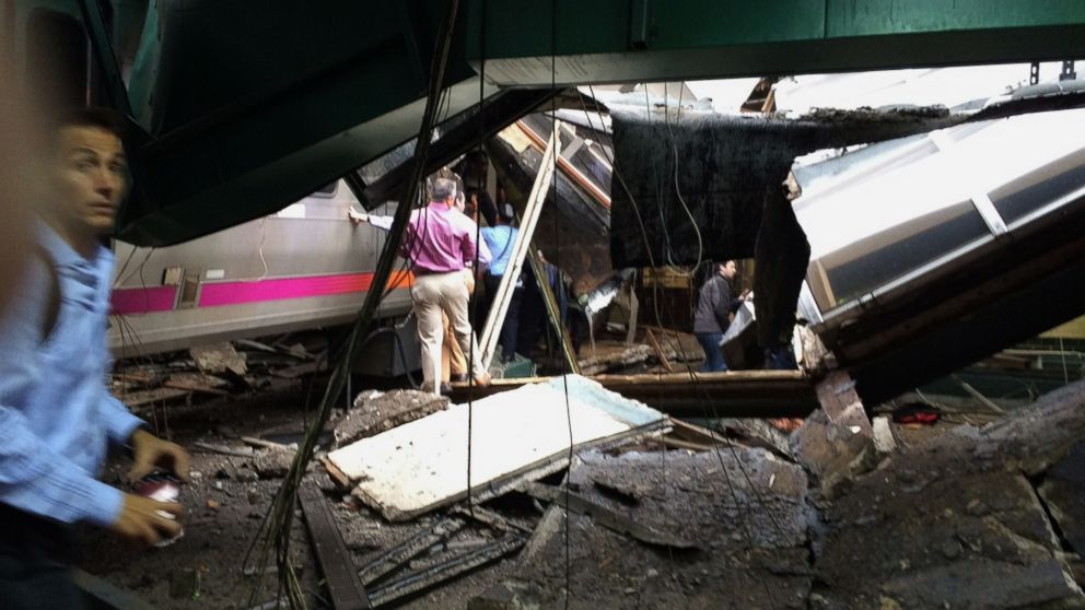 People examine the wreckage of a New Jersey Transit commuter train that crashed into the train station during the morning rush hour in Hoboken, New Jersey, Sept. 29, 2016.