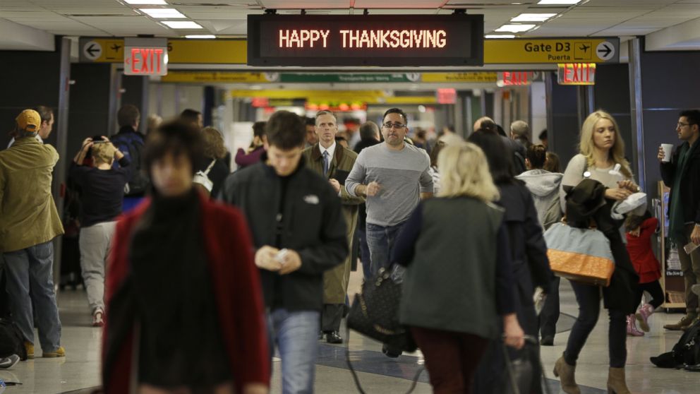 Travelers walk under a sign reading "Happy Thanksgiving" at LaGuardia Airport in New York, Nov. 26, 2013.