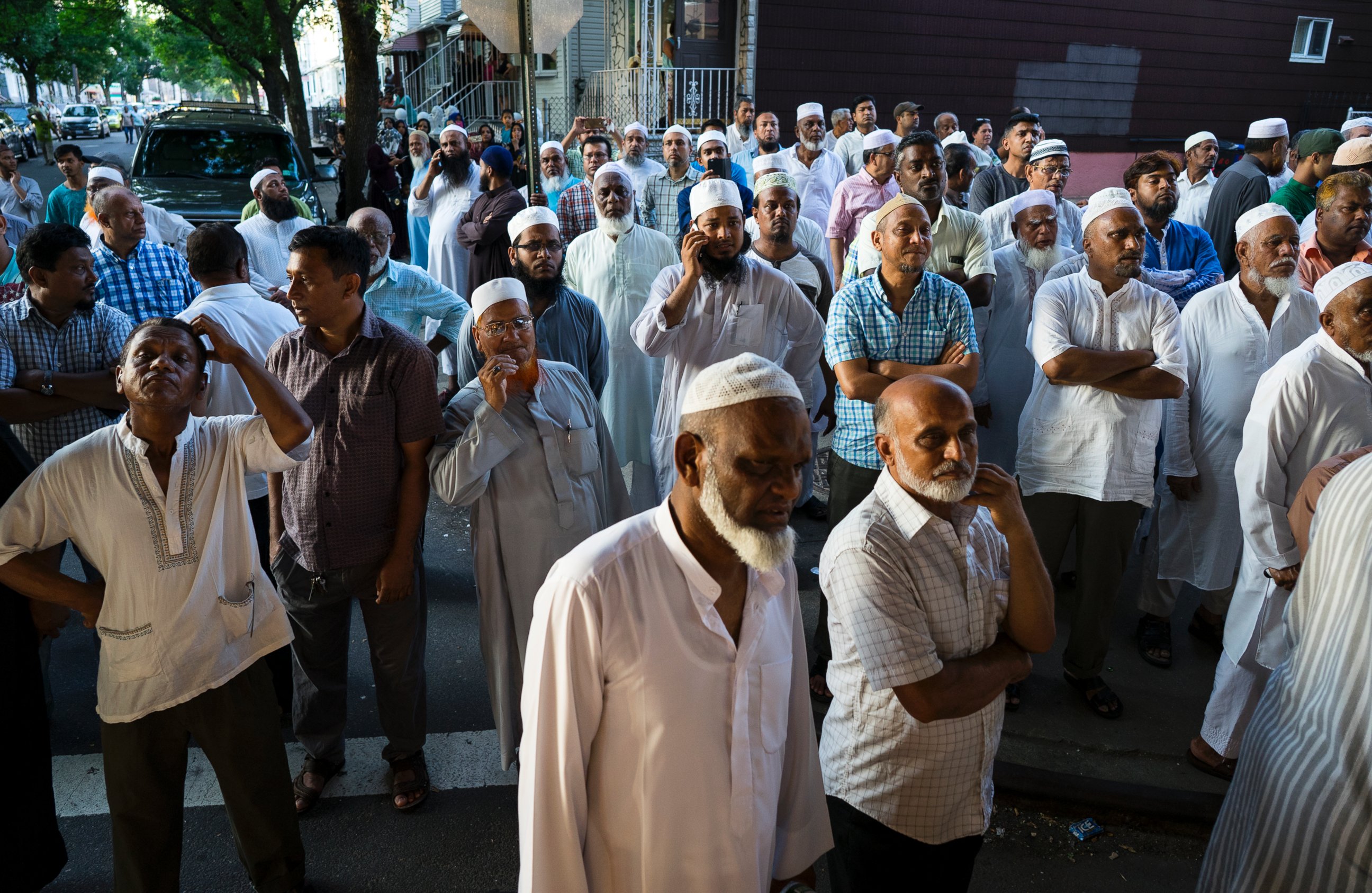 PHOTO: In this Saturday, Aug. 13, 2016, photo, people gather near a crime scene for a demonstration after the leader of a New York City mosque and an associate were fatally shot.